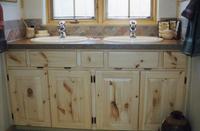 Thumb vanity  traditional style  knotty pine  light color  standard overlay with exposed hinges  small drawers between sink sections