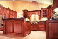 Thumb kitchen  traditional style  knotty cherry  cherry color  glazed  raised panel  flush mount  angled wood hood  stucco top  raised bar neck with panel back of island  flutes  carved corbels