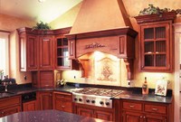 Thumb kitchen  traditional style  knotty cherry  cherry color  glazed  raised panel  raised panel ends  angled wood hood  stucco top   glass grid doors  appliance garage  flutes at rangetop  wood dishwasher front